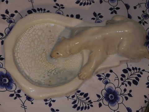 Polar bear drinking from crystalline bowl